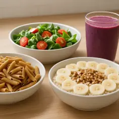 Zdrowa kolacja przed biegiem: owsianka z bananem i orzechami, makaron pełnoziarnisty, sałatka z pomidorkami i koktajl jagodowy.