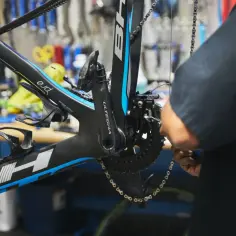 Mechanik dokonuje regulacji przedniej przerzutki w rowerze szosowym.