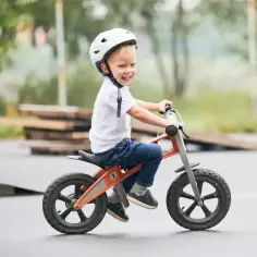 Uśmiechnięty chłopiec w kasku na rowerku biegowym, idealnym dla 2 latka. Ranking najlepszych modeli!